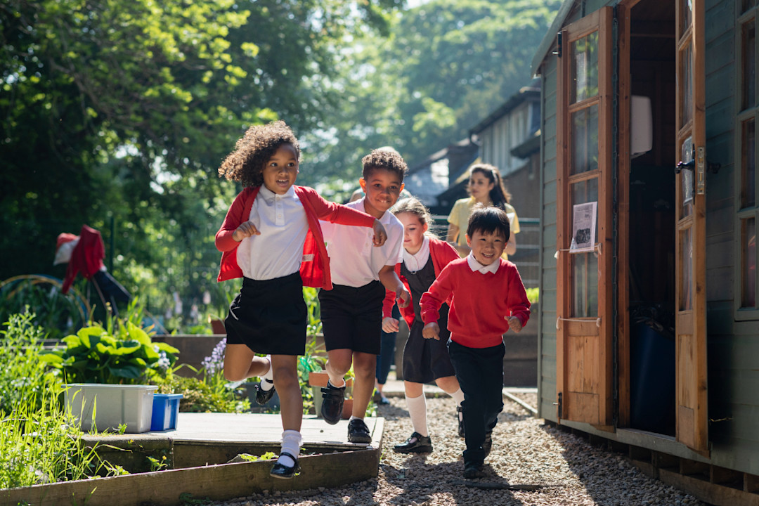 A group of school children running in the school yard- GettyImages