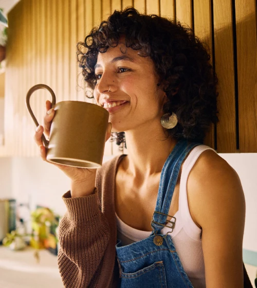 A lady is enjoying her coffee and looks happy