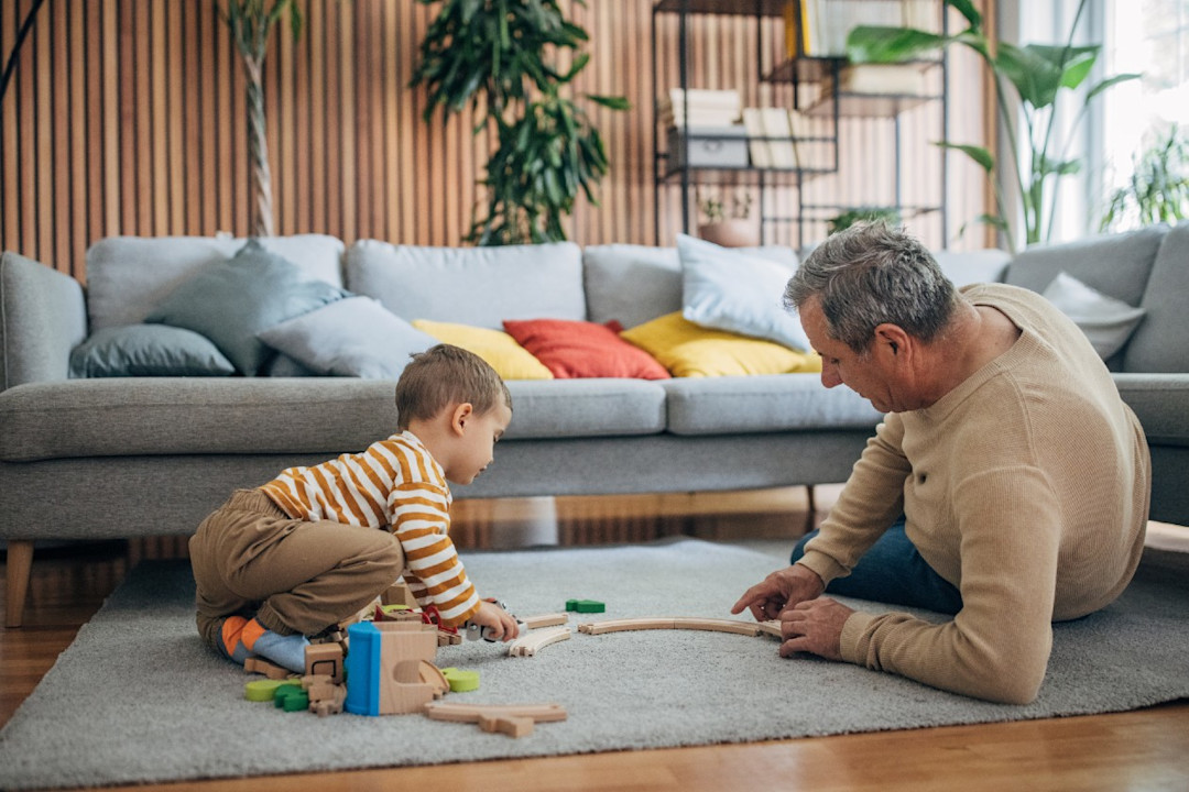 Grandfather and grandson playing with puzzle pieces in a living room.jpg