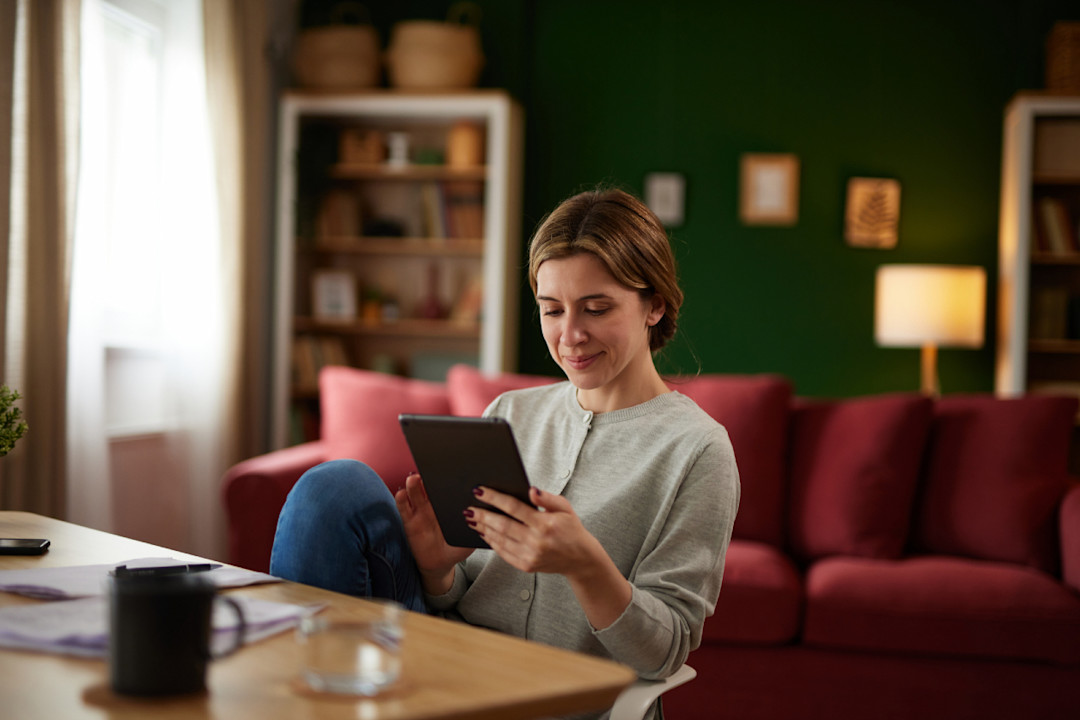 Woman using digital tablet to check her finances at home office.jpg